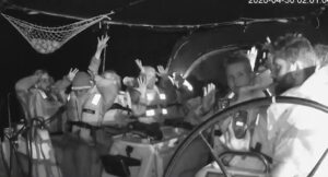 Activistas detenidos en un bote con manos levantadas
