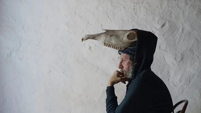 Hombre pensativo con un cr&aacute;neo en la cabeza en un fondo blanco