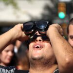 Hombre observando el eclipse solar con gafas especiales en Mallorca