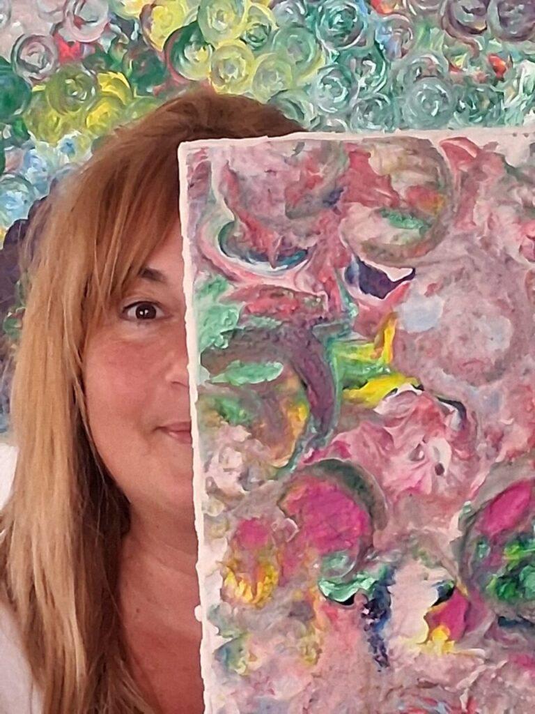 Virginia Siquier sosteniendo una obra de arte colorida