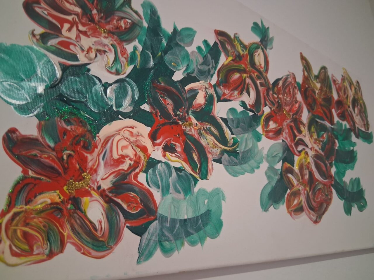 Pintura abstracta con flores rojas y verdes en un lienzo