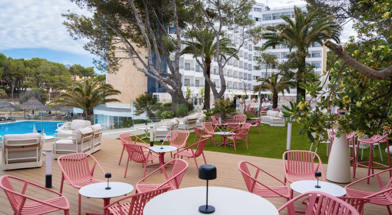 Terraza con sillas rosadas y piscina en Vibra Hotels Mallorca