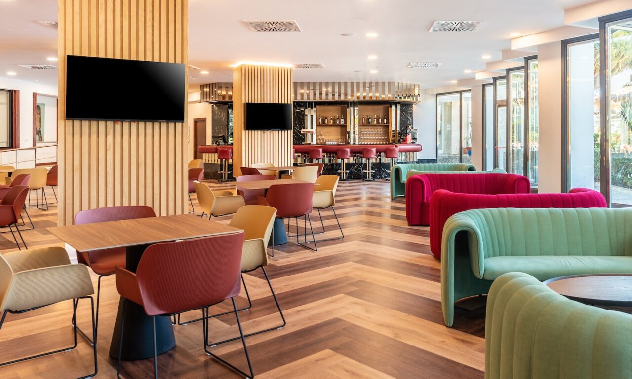 Interior moderno de un hotel con sillones coloridos y barra