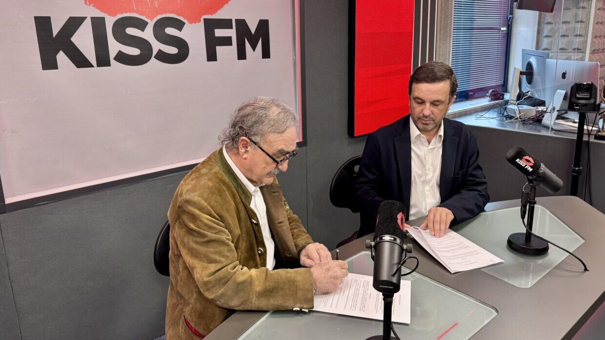 Blas Herrero y Gabriel Torrens firmando un acuerdo en estudio de radio