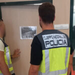 Dos agentes de la Policía Nacional frente a una puerta de investigación