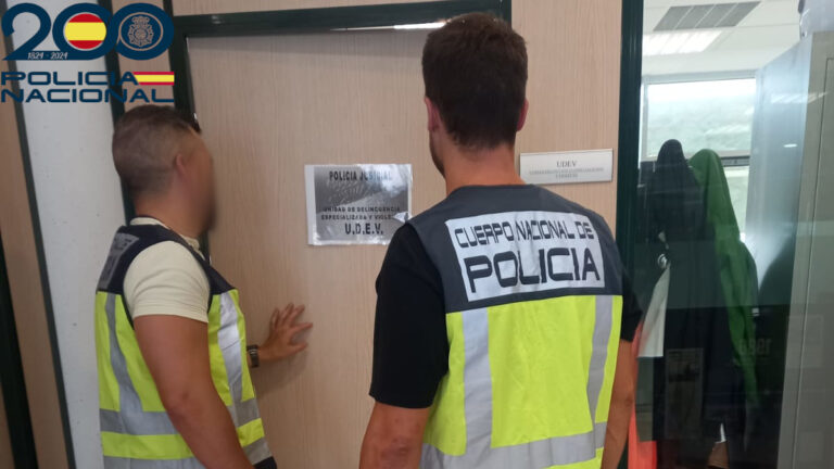 Dos agentes de la Polic&iacute;a Nacional frente a una puerta de investigaci&oacute;n