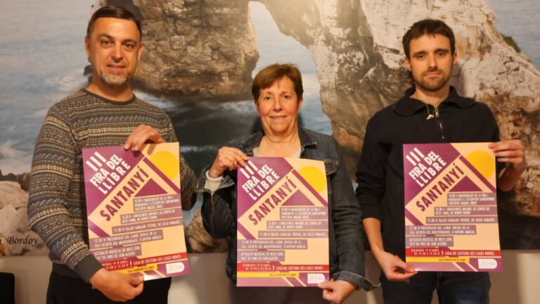 Tres personas sosteniendo carteles de la III Fira del Llibre en Santany&iacute;