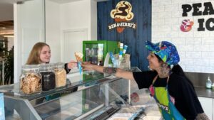 Empleada de helader&iacute;a Ben & Jerry's sirviendo helado a una cliente en Ibiza