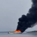 Yate en llamas emitiendo humo negro en el mar