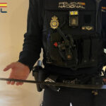 Agente de polic&iacute;a mostrando un arma intervenida tras una agresi&oacute;n a una pareja.