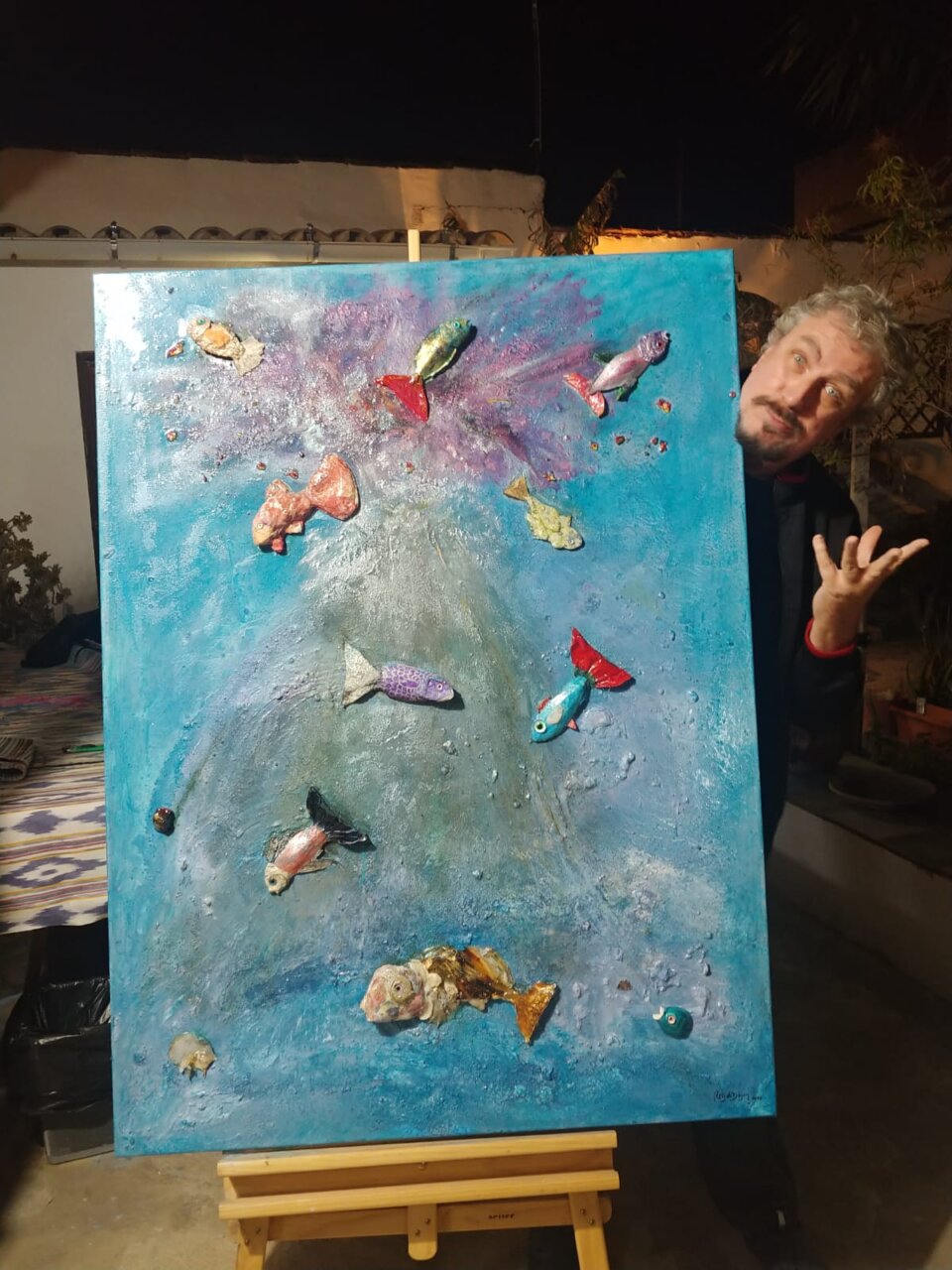 Jaime Roig de Diego posando junto a su pintura abstracta de peces.