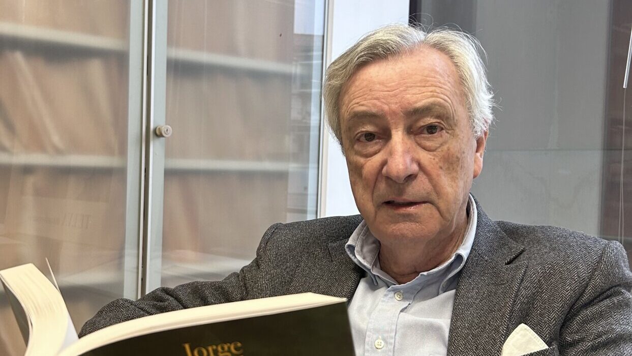 Jorge Dezcallar sosteniendo su novela Pez Negro en un ambiente interior