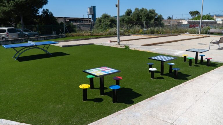 Mesas de ajedrez, parchís y ping pong en un parque infantil.