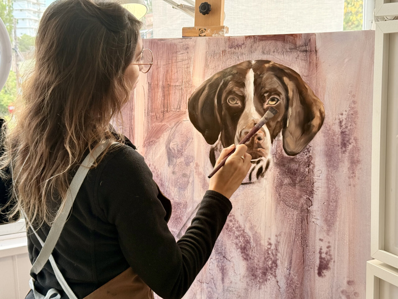 Natalia Aguilar pintando un retrato de un perro en su taller