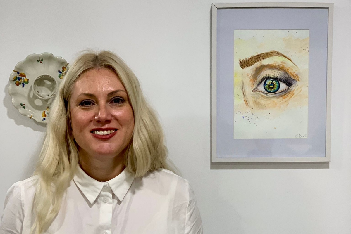 Olga Bortnyk, residente en Mallorca, sonríe frente a una pintura