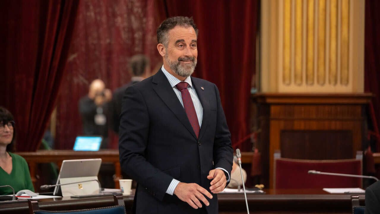 Hombre de pie en el parlamento con fondo de cortinas rojas