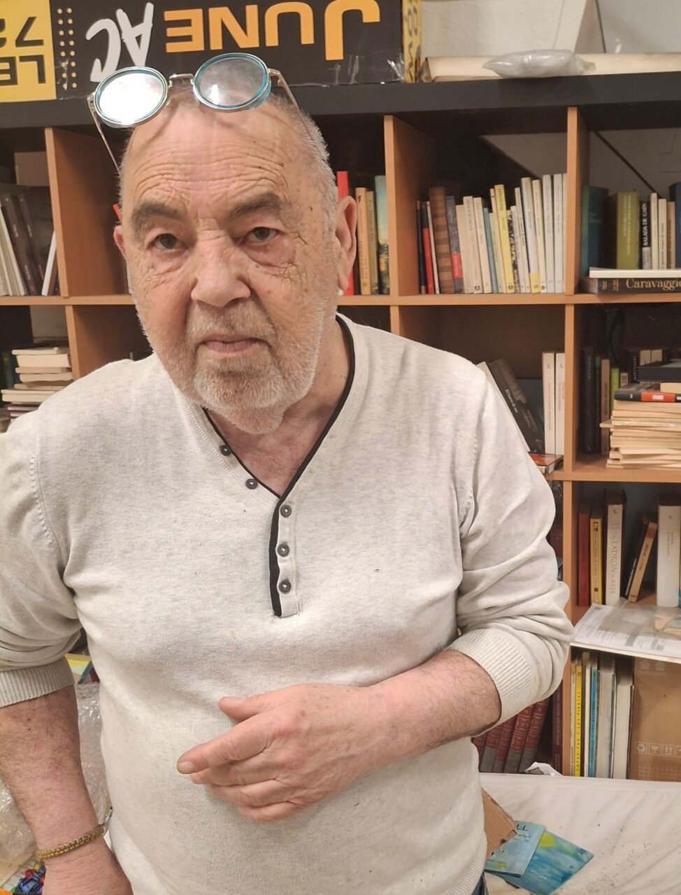 Pep Coll en su taller rodeado de libros y materiales artísticos