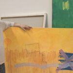 Pep Coll mostrando una de sus obras en su taller de arte.