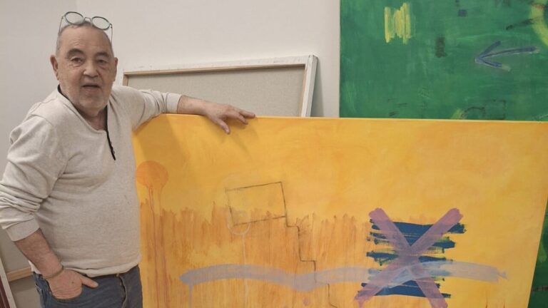 Pep Coll mostrando una de sus obras en su taller de arte.
