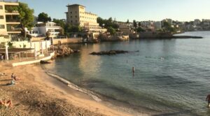 Vista de la playa Bugambilia en Calvi&agrave; con personas disfrutando del agua.