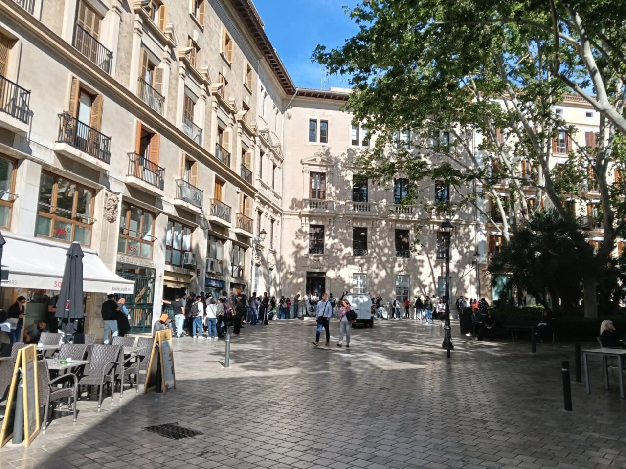 Plaza con edificios y personas en una jornada de regularizaci&oacute;n de inmigrantes.