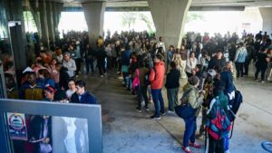 Multitud de personas esperando en un edificio para regularizaci&oacute;n de migrantes