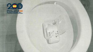 Sistema de alarma roto tirado en un inodoro blanco