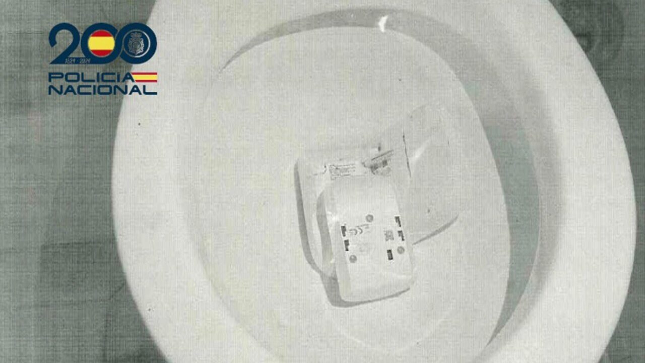 Sistema de alarma roto tirado en un inodoro blanco