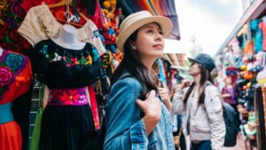 Turista explorando un colorido mercado lleno de ropa tradicional