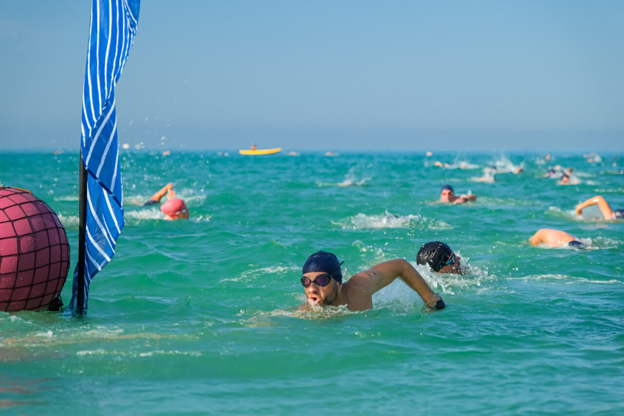 Nadadores compitiendo en el mar durante un evento en Palma Beach