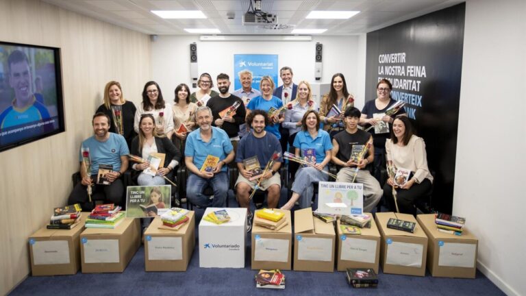 Grupo de voluntarios sosteniendo libros donados por CaixaBank en Baleares