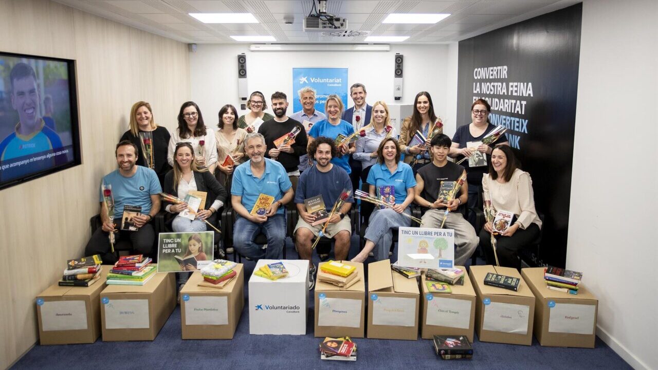 Grupo de voluntarios sosteniendo libros donados por CaixaBank en Baleares