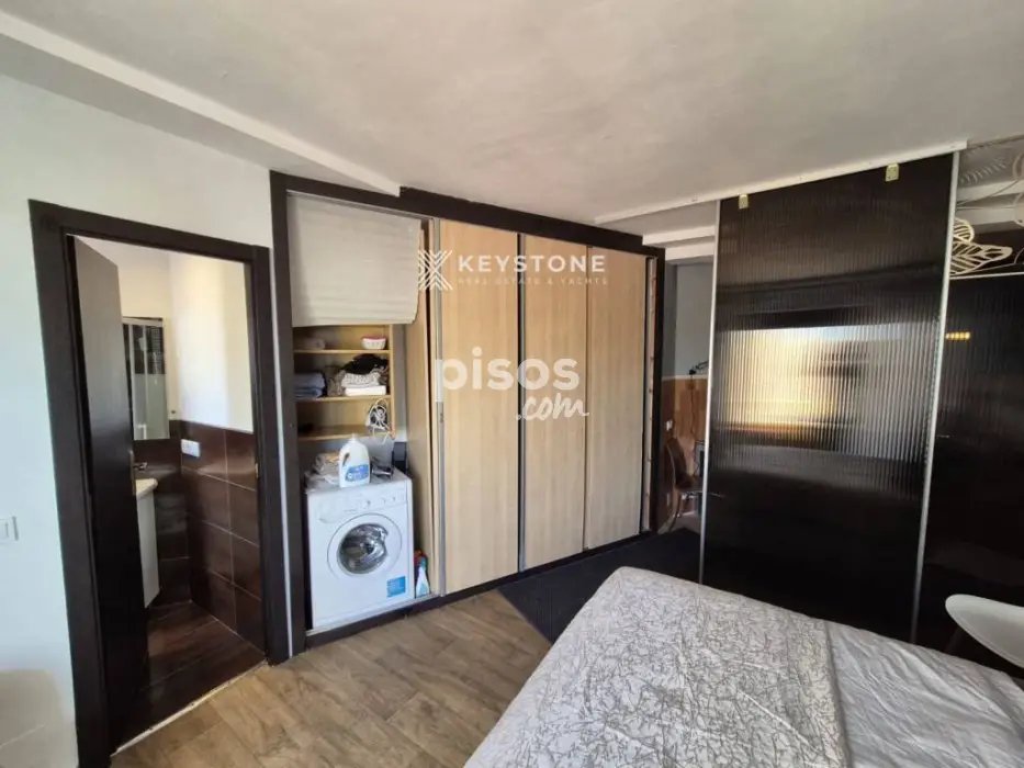 Interior de un estudio pequeño en Palma con cama y lavadora