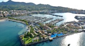 Vista a&eacute;rea de una marina con yates y edificios en la costa