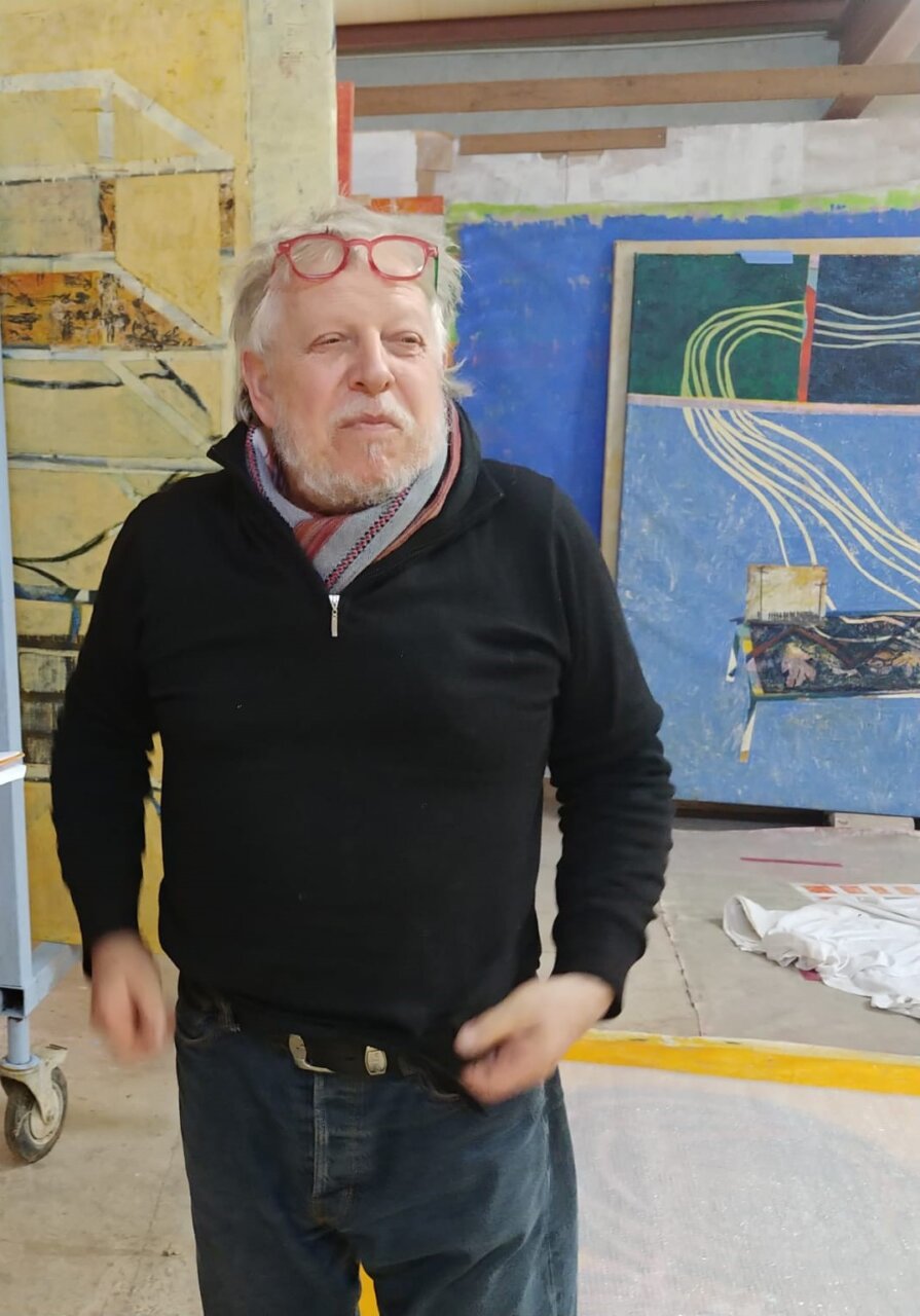 Horacio Sapere en su estudio rodeado de pinturas coloridas