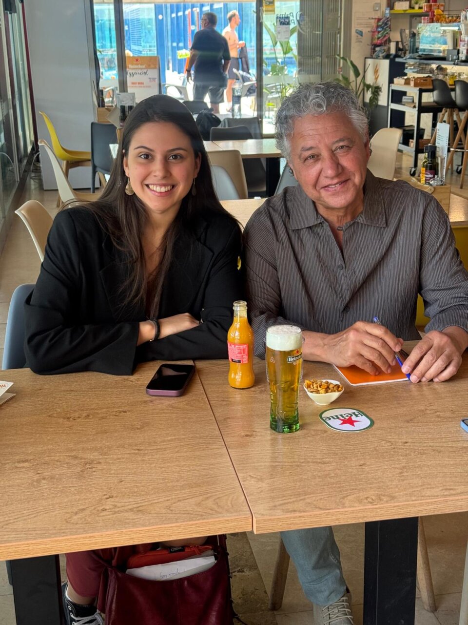 Águeda Morey y un hombre en una cafetería con bebidas y snacks