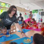 Educadora sirviendo comida a niños en Fundación La Matica