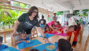 Educadora sirviendo comida a ni&ntilde;os en Fundaci&oacute;n La Matica