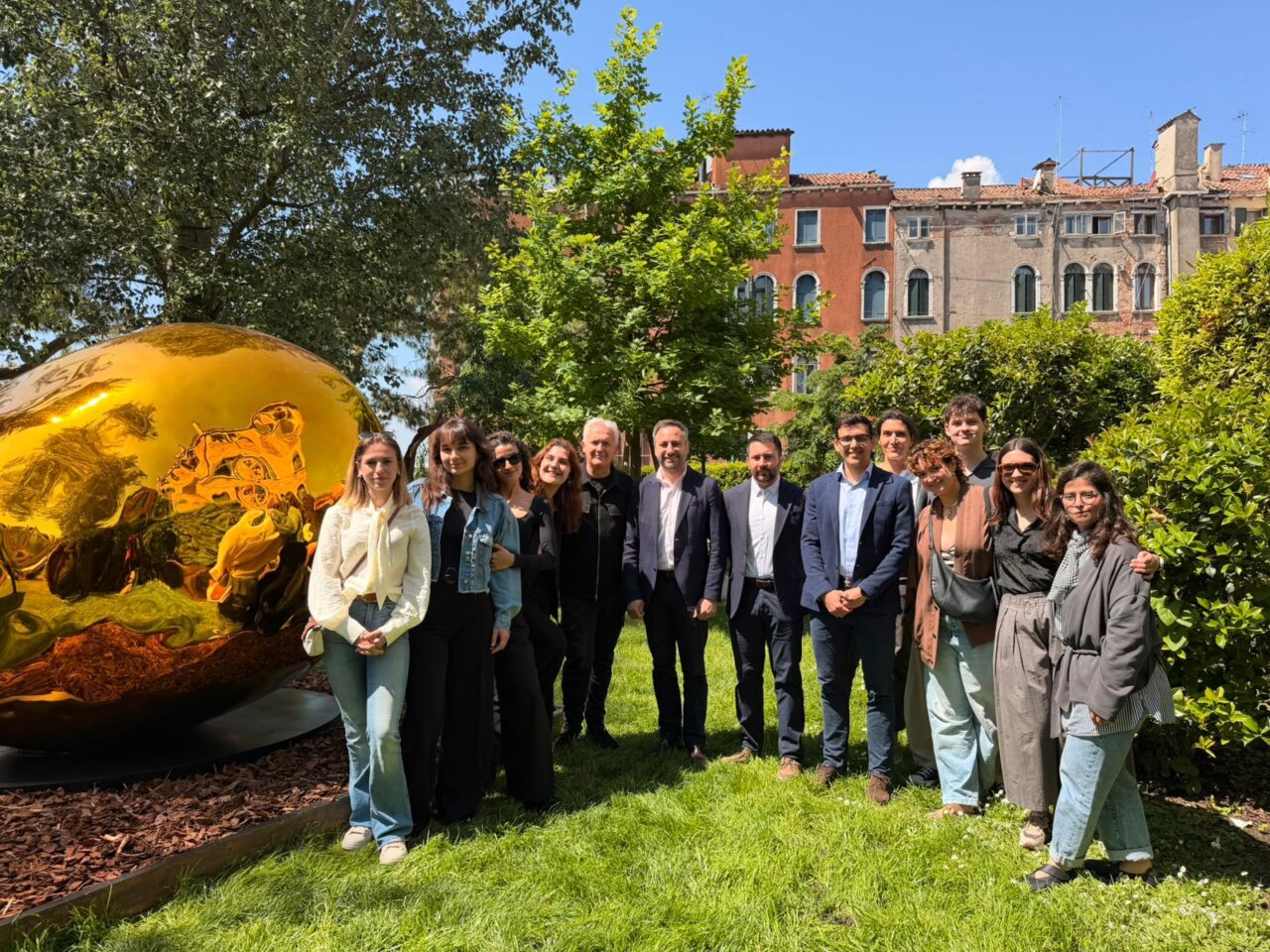 Grupo de alumnos de ADEMA en la Bienal de Venecia junto a una escultura dorada.
