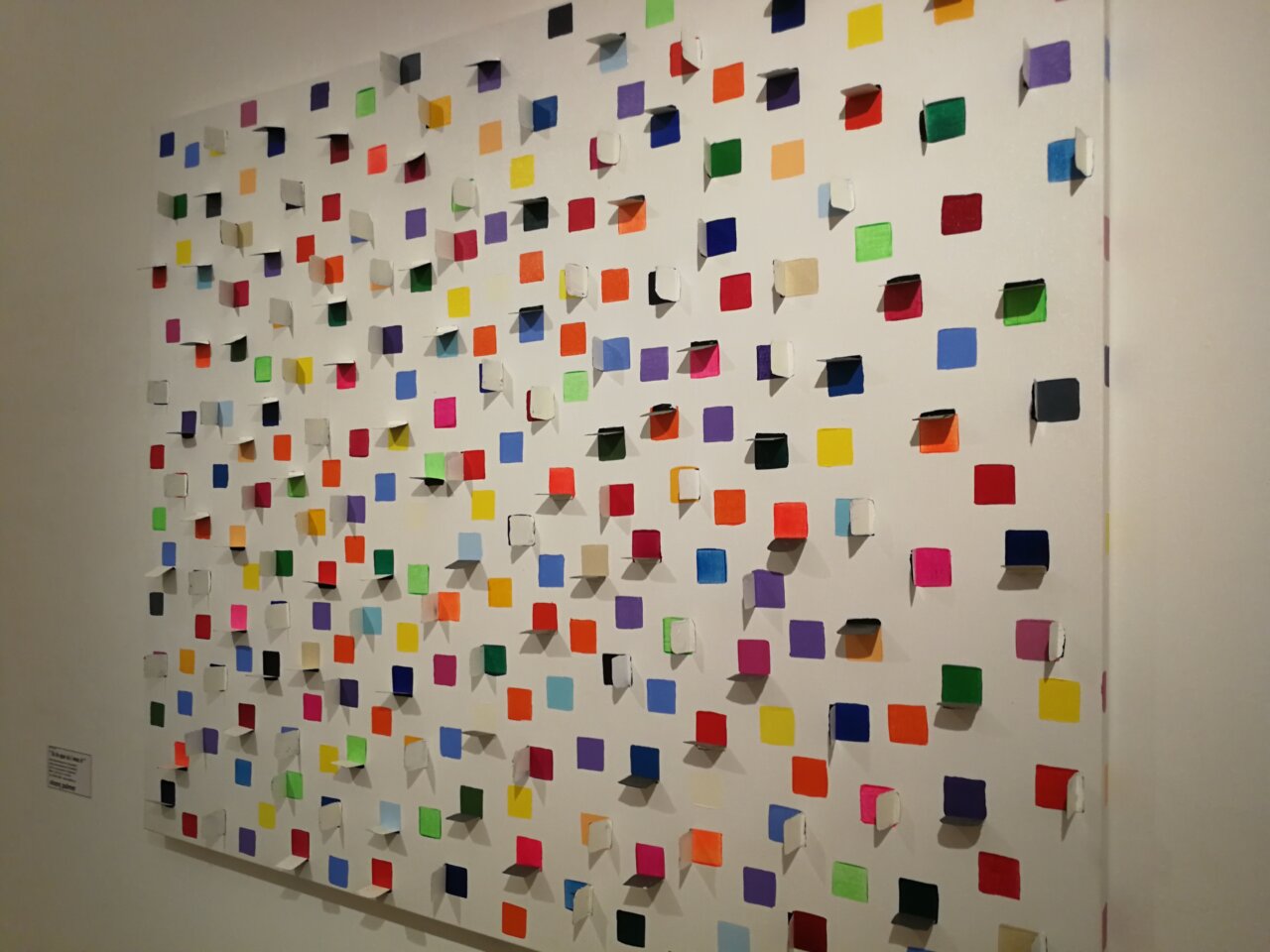 Mural colorido con cuadrados de papel en diferentes tonos