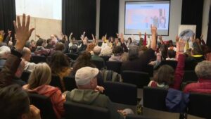 Asamblea del GOB con participantes levantando las manos