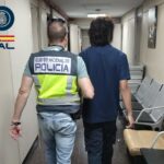 Agentes de la Polic&iacute;a Nacional arrestando a un sospechoso en un pasillo
