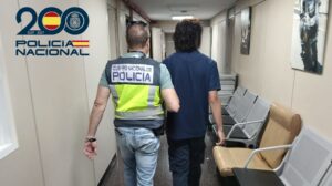 Agentes de la Polic&iacute;a Nacional arrestando a un sospechoso en un pasillo