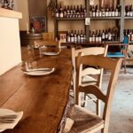 Mesa de madera en el restaurante Cuina Vivant con platos y copas.