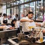 Estudiantes en un curso de hosteler&iacute;a cocinando en una cocina moderna