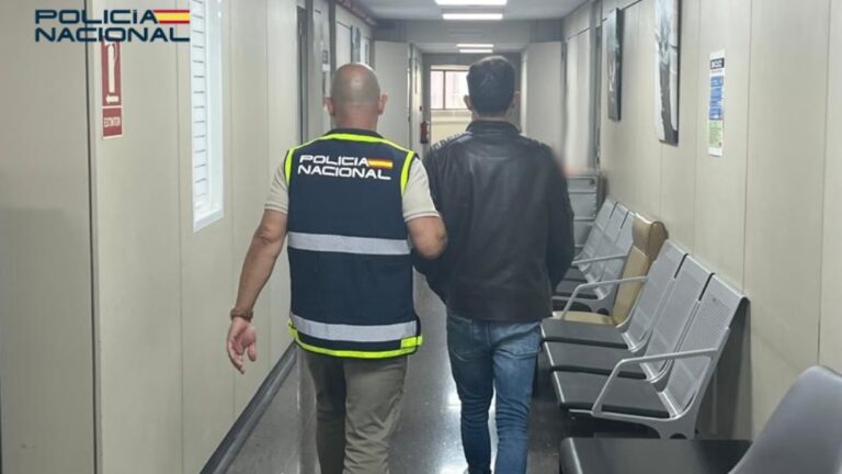 Agente de policía deteniendo a un hombre en un pasillo