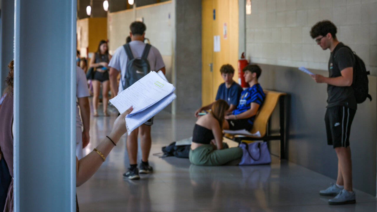 Estudiantes en un pasillo con papeles en la mano durante la Selectividad