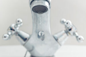 Grifo de cocina goteando con agua en una gota
