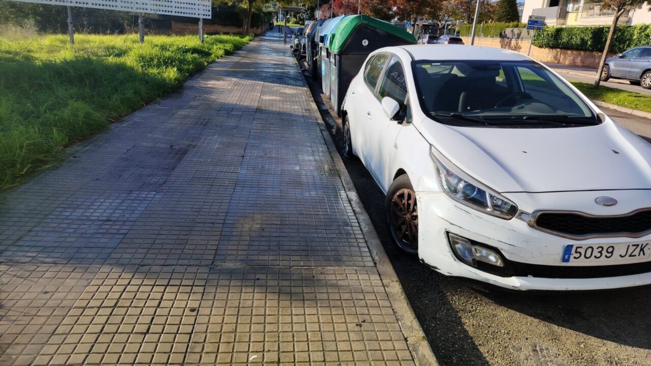 Calle limpia en Palma con contenedores y un coche estacionado