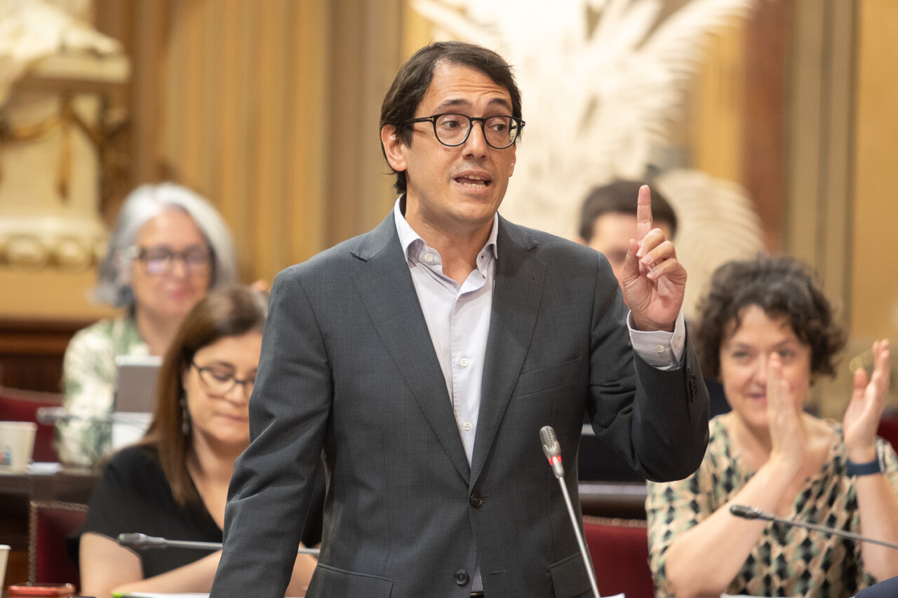 Un hombre hablando en el parlamento con gestos expresivos.